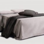 Canapé Convertible 3 places en tissu gris taupe avec passepoil en gris anthracite. Il est ouvert en lit double avec deux coussins gris anthracite.